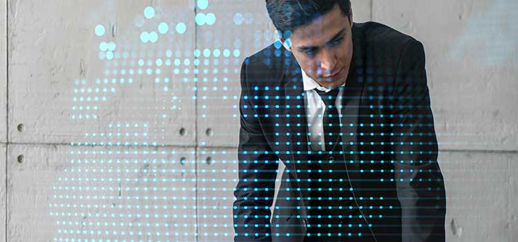 man in suit leans on desk and reviews data protection reports